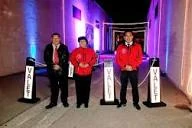 A&A Parking Services valet attendants beside branded valet parking stanchion signs in a lit driveway at an evening event