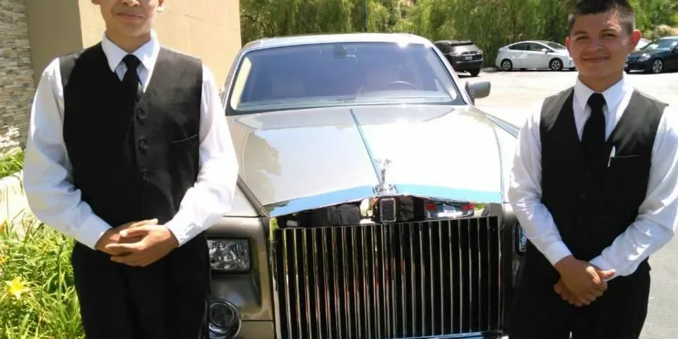 A&A Parking Services valet attendants in black vests beside a Rolls-Royce Phantom at a Los Angeles venue