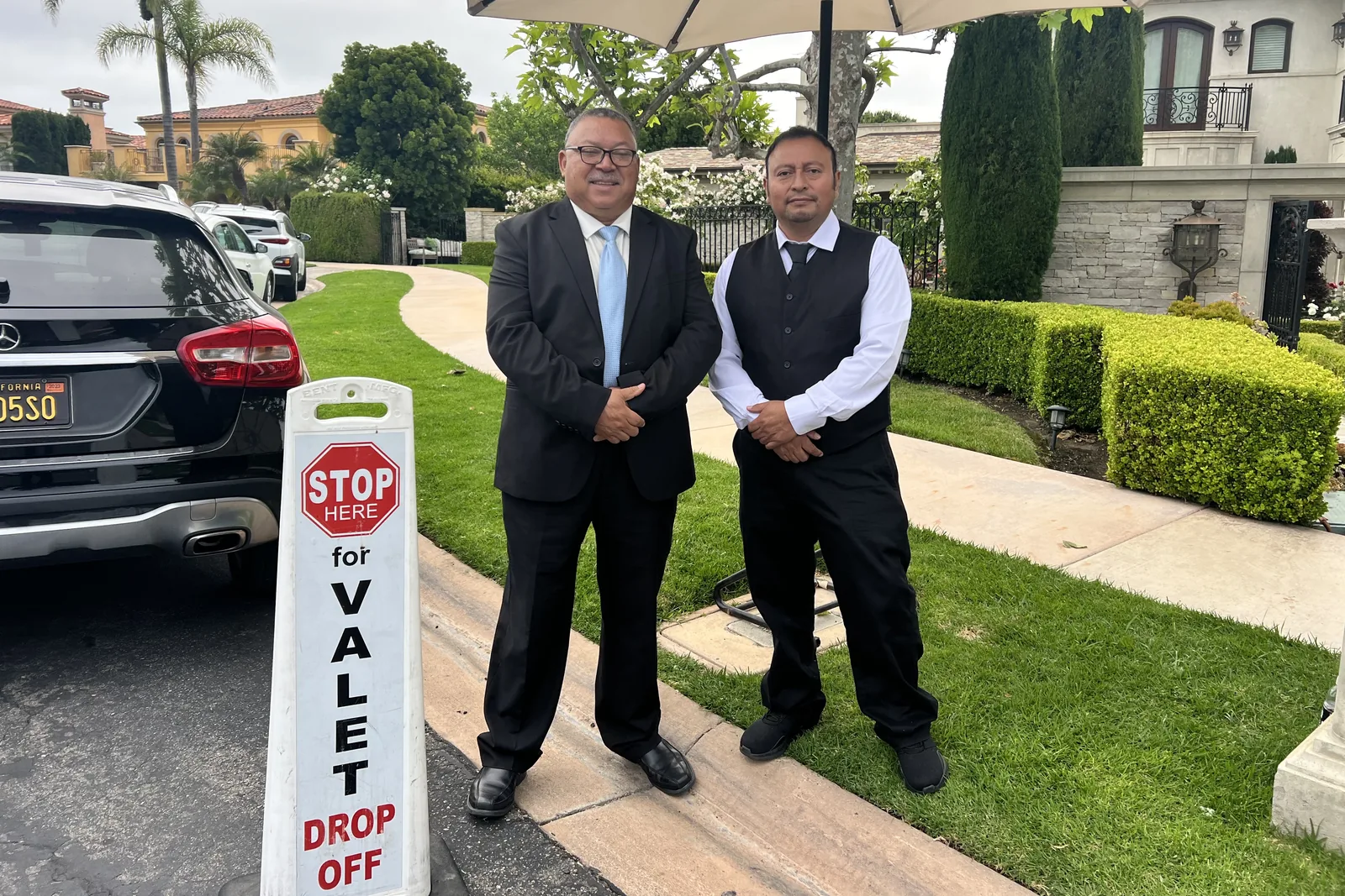 A&A Parking Services valet attendants at a STOP HERE FOR VALET DROP OFF sign outside a gated community in Encino